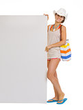 Full length portrait of happy beach young woman showing blank bi