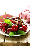 cherry berries with mint leaves on a wooden table