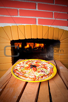 Pizza baking with wood fire in the oven 