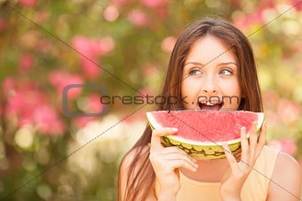 Portrait of a beautiful young woman eating watermelon