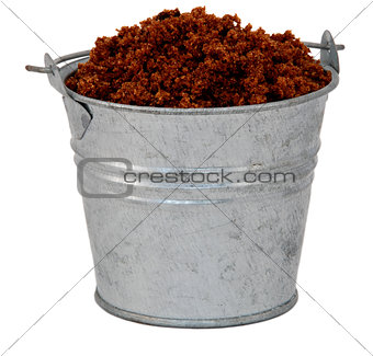 Dark brown soft / muscovado sugar in a miniature metal bucket