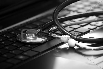 Silver stethoscope lying down on an laptop