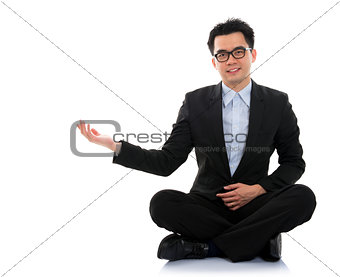 Asian business man showing blank space sit on floor