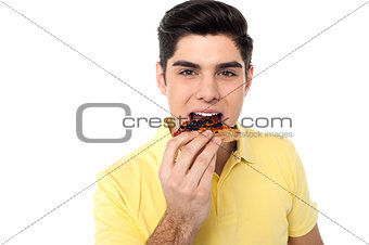 Handsome guy enjoying yummy pizza slice
