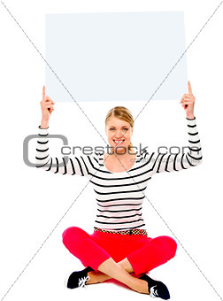 Seated woman showing blank billborad