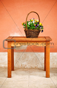 basket with flowers on wooden table