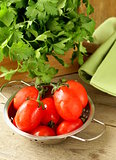 fresh wet cherry tomatoes and bunch of parsley on the table