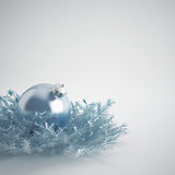 Christmas ball of gentle blue color in an environment of a tinsels and decorations