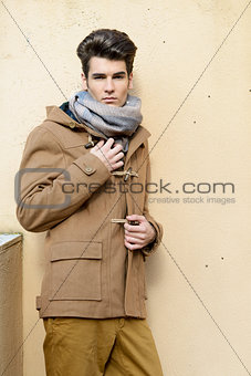 Attractive young handsome man, model of fashion in urban backgro