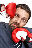 Close-up young businessman struck in the face by hands in boxing gloves