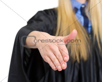 Closeup on woman in graduation gown stretching hand for handshak