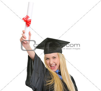 Happy young woman in graduation gown with diploma rejoicing succ