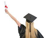 Woman in graduation gown with diploma rejoicing success . rear v
