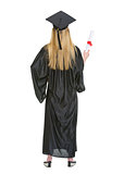 Full length portrait of woman in graduation gown showing diploma