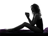  woman drinking sitting on bed silhouette