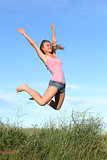 Blonde teenager girl jumping happy in the mountain