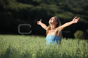 Beautiful teenager girl breathing happy in a green meadow