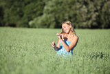 Beautiful teenager girl touching a oat stem