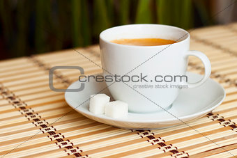 cup of coffee on bamboo tablecloth