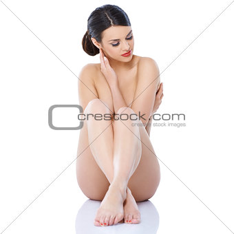 Naked girl sitting isolated with legs crossed