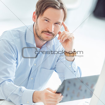 Young hansome businessman sitting at the desk