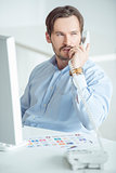 Busy businessman talking phone at his desk