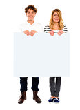 Young couple standing with white board