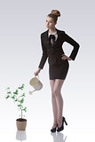 pretty business woman watering money plant