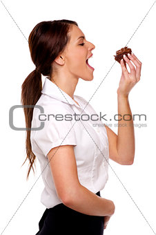 Business woman biting into chocolate cake