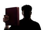 Man figure in silhouette showing a book