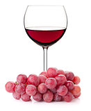 Red wine in glass with red grape branch