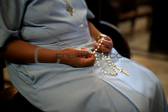 Women and religion, catholic sister praying in church, holding c