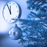 christmas tree with decorations on a background wall and clock