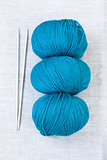 Three bright balls of yarn and knitting needles