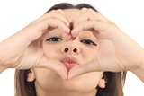 Pretty woman making a heart shape with her hands