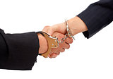 Handshake linked with handcuffs