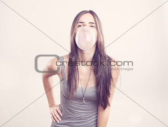 Young woman blowing a bubble gum