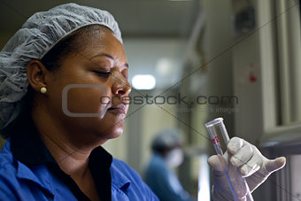 Woman working in pharamaceutical lab with test tubes