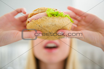 Closeup on teenager girl eating burger