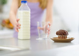 Closeup on chocolate muffin and teenager girl with milk in backg