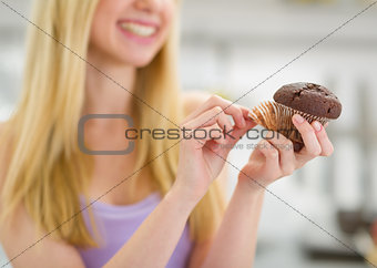 Closeup on chocolate muffin in hand of teenager girl