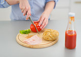 Closeup on young woman making sandwich in kitchen