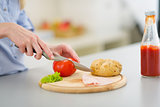 Closeup on young woman making sandwich in kitchen