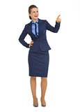 Full length portrait of happy business woman pointing on copy sp
