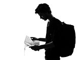 young man silhouette backpacker reading map