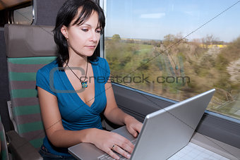 woman in a train computing laptop computer 