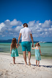Father and his two kids enjoy walking by the sea