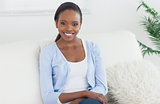 Smiling woman sitting on a sofa looking at camera