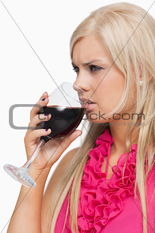 Serious blonde drinking a glass of wine