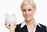 Smiling businesswoman holding a piggy-bank